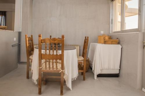 a dining room with a table and two chairs and a table and a window at Saronicos Gulf View in Anavissos in Anavissos
