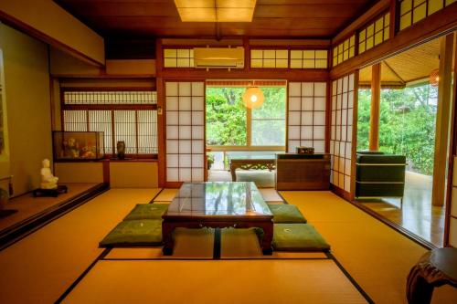 a room with a table in the middle of a room at 円山山荘 Maruyama villa 自然と調和し和の美を感じる岡山市内屈指の豪邸宿 supported by COCOSTAY in Okayama