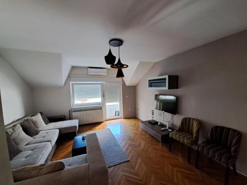 - un salon avec un canapé et une table dans l'établissement L&M 2 Apartman, à Bijeljina