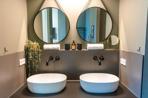 zwei Waschbecken im Bad mit zwei Spiegeln in der Unterkunft CABANA - TheView - 10th Floor - Terrasse - Waterfront - Hafenviertel in Oldenburg