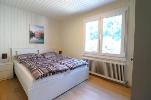 a bedroom with a bed and a window at Montfort Apartments - Feldkirch in Feldkirch