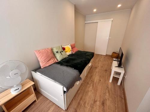 een kleine slaapkamer met een bed en een flatscreen-tv bij Moradia Fonte Nova Setúbal in Setúbal