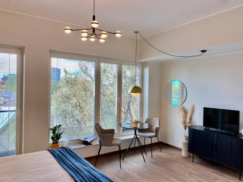 1 dormitorio con cama, mesa y algunas ventanas en Elegance Apartment - City Centre Free Parking en Tallin
