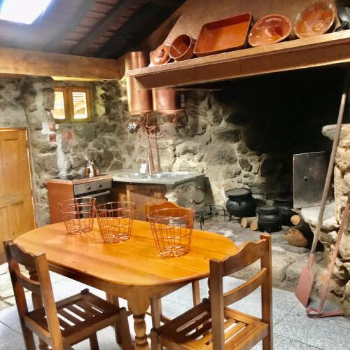 a kitchen with a wooden table with baskets on it at Quinta dos Carvalhos The Wine House Farm in Center of Lamego - Capital of the Douro in Lamego