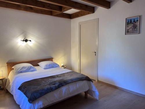 - une chambre dotée d'un grand lit avec des draps et des oreillers blancs dans l'établissement Chalet Laguiole Aubrac, à Laguiole