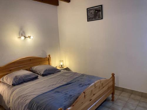 um quarto com uma grande cama de madeira e 2 almofadas em Chalet Laguiole Aubrac em Laguiole