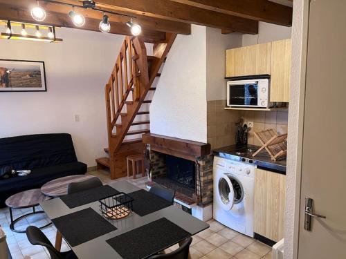 uma sala de estar com uma mesa e uma cozinha com lareira em Chalet Laguiole Aubrac em Laguiole