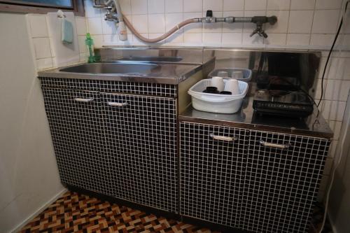 a small kitchen with a sink and a counter at Apartment Namba Daikoku in Osaka