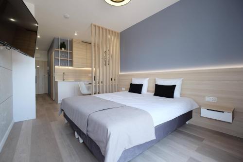 a bedroom with a large white bed with black pillows at Apartamenty Centrum in Białystok