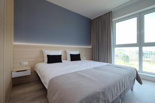 a bedroom with a large white bed with two pillows at Apartamenty Centrum in Białystok