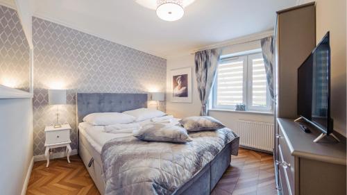 um quarto com uma cama com almofadas em Apartamenty Sun & Snow Hel Centrum em Hel