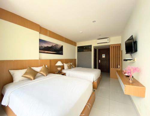 a hotel room with two beds and a television at Conson Hotel in Con Dao