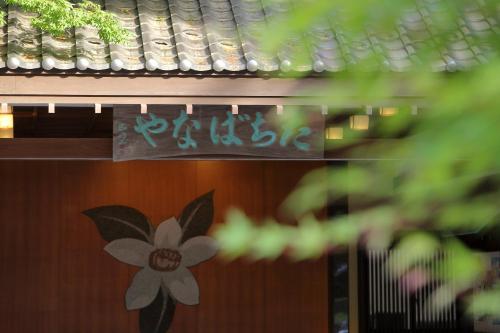 a sign on a building with a flower on it at Tachibanaya in Tsuruoka