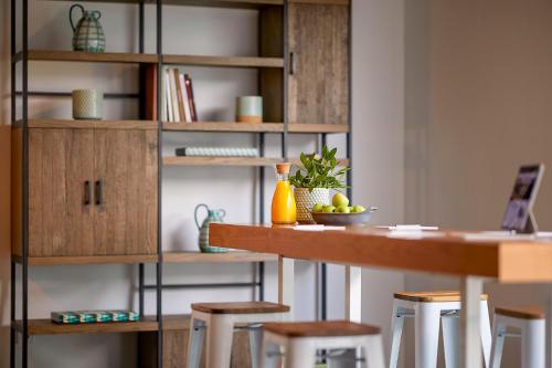 a kitchen with a table and some stools at Octant Santiago in Santiago do Cacém