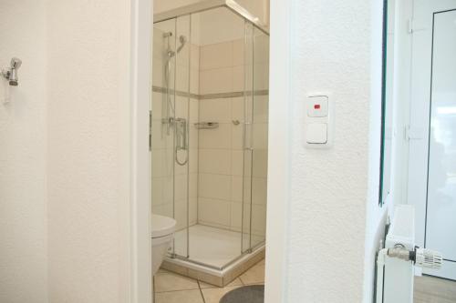 La salle de bains est pourvue d'une douche et de toilettes. dans l'établissement Grömitz- Center I App 767 inkl WLAN, à Grömitz