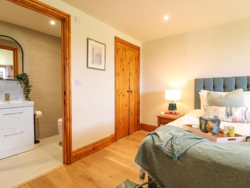 a bedroom with a large bed and a mirror at Rowtor in Matlock