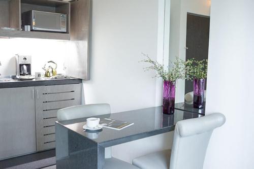 a kitchen with a table and two chairs and a counter at Suites Contempo in Mexico City
