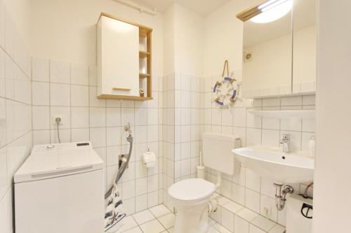 uma casa de banho branca com um WC e um lavatório em Zweite Heimat inkl WLAN em Grömitz