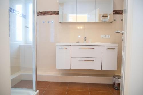 y baño con lavabo blanco y ducha. en Haus Ostseeblick App 8 inkl WLAN, en Grömitz