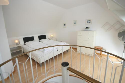 - une chambre blanche avec un lit et un escalier dans l'établissement Haus Deichgraf Whg 12, à Grömitz