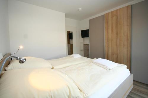 una camera da letto con un grande letto bianco e una lampada di Haffkamp 21a Whg 3 inkl WLAN a Grömitz