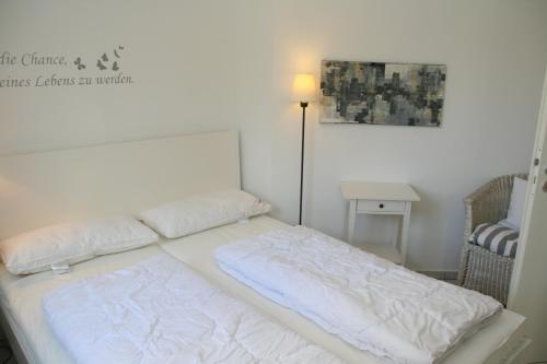 - un lit avec 2 oreillers dans l'établissement Residenz am Kurpark App 10 inkl WLAN, à Grömitz
