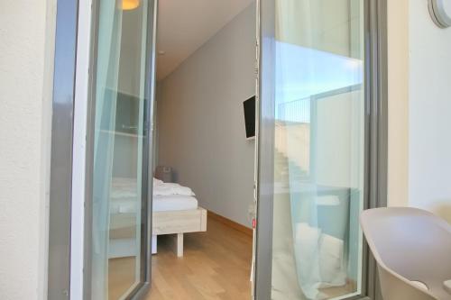 uma divisória de vidro num quarto com uma cama em Seeblick Gartenmaisonette 6 inkl WLAN em Grömitz