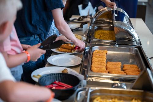 a group of people preparing food at a buffet at Astir Odysseus Kos Resort and Spa in Tigaki