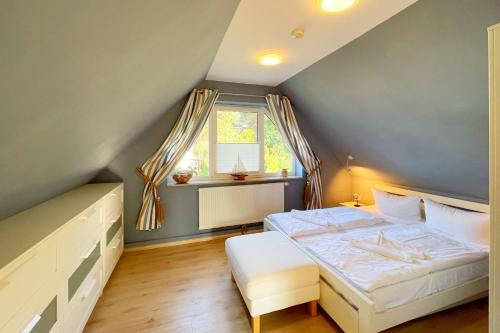 a bedroom with a large bed and a window at Ferienhaus Dresdner Weg 16 in Loddin