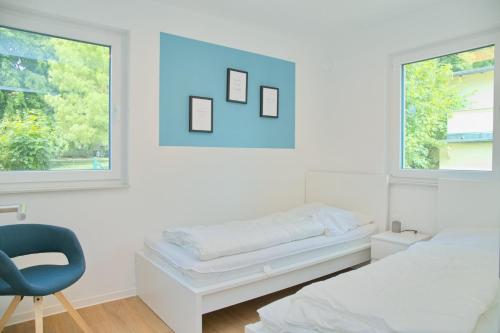 - une chambre avec un lit, une chaise et deux fenêtres dans l'établissement Weiße Villa Whg 5 inkl WLAN, à Grömitz