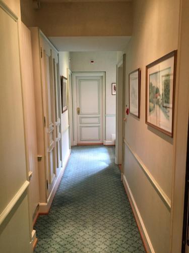 a hallway with a white door and some pictures at Le Manoir Au Lac in Gérardmer