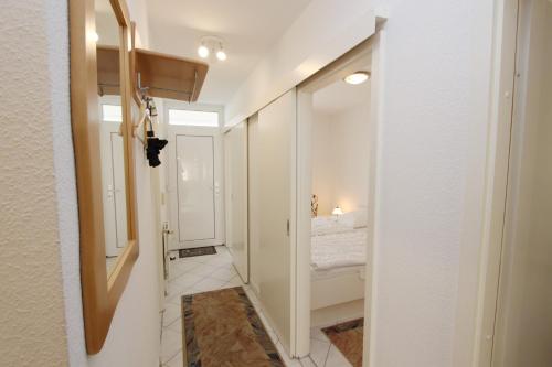 pasillo con habitación con cama y espejo en Grömitz- Center I App 540 inkl WLAN, en Grömitz