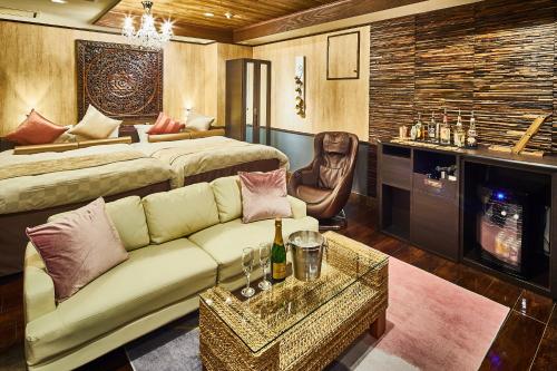 ein Wohnzimmer mit einem Sofa und einem Bett in der Unterkunft Hotel Balian Resort Kinshicho in Tokio