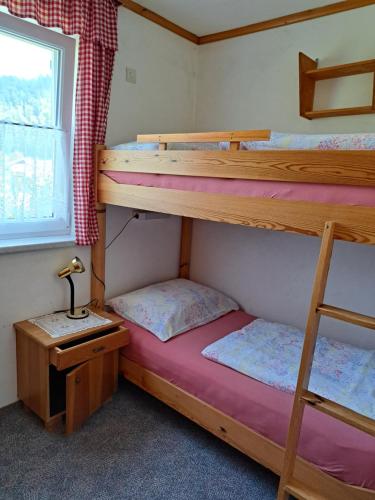 two bunk beds in a room with a window at Bungalow Raschun Grabelsdorf Etruskerweg 12 / 9122 St. Kanzian in Grabelsdorf