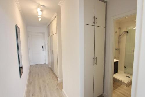 un couloir avec des armoires blanches et une salle de bains. dans l'établissement Villa am Meer App 53 inkl WLAN, à Grömitz
