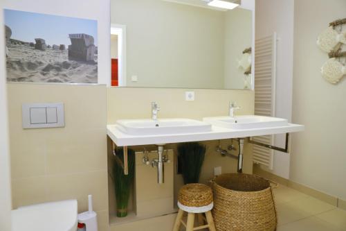 een badkamer met 2 wastafels en een spiegel bij Seeblick Seeloft 2 inkl WLAN in Grömitz