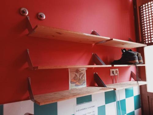 a room with wooden shelves on a red wall at Albergue de Peregrinos Villa de Luarca in Luarca