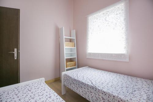 a small bedroom with two beds and a window at Apartment Gino in Ravni