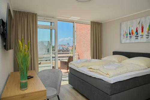 - une chambre avec un lit, une table et un balcon dans l'établissement Haus Belvedere App 47 WLAN inkl, à Grömitz