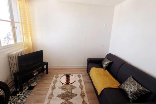 un salon avec un canapé et une table dans l'établissement Le petit studio senlisien, à Senlis