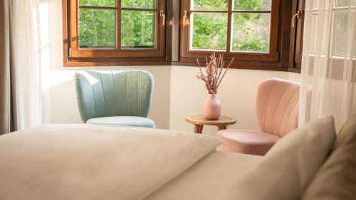 a room with two chairs and a couch and windows at Boutique Hotel Soyka in Špindlerův Mlýn
