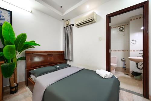 a bedroom with a bed and a bathroom with a sink at Ohio Hotel & Apartment in Ho Chi Minh City