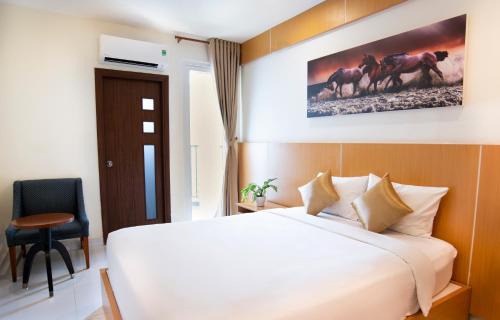 a hotel room with a bed and a chair at Conson Hotel in Con Dao