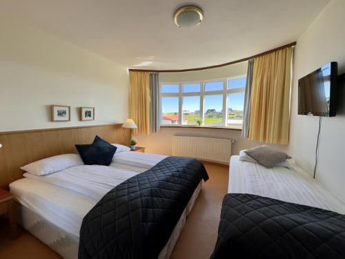 Habitación de hotel con 2 camas y ventana en Adventure Hotel Hellissandur, en Hellissandur
