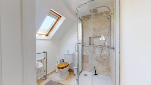 a bathroom with a shower and a toilet at Spring Hill Cottage in Bladon