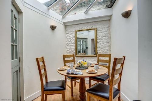 a dining room with a table and chairs and a mirror at Browns Lane in Woodstock