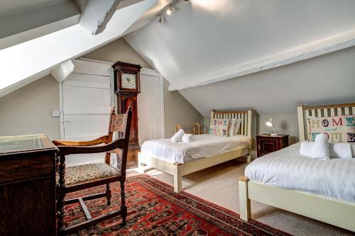 a bedroom with two beds and a desk and a clock at Browns Lane in Woodstock