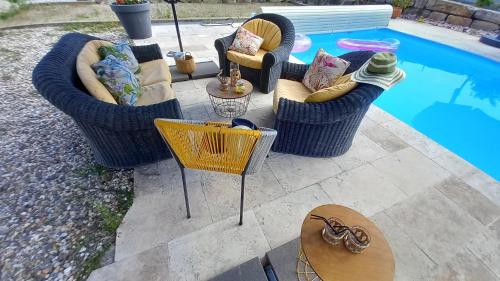 a group of chairs and tables next to a pool at Millésime in Perville