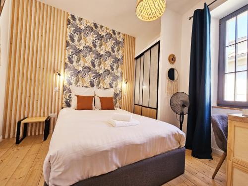 une chambre avec un grand lit dans une pièce dans l'établissement Le jardin vert, paisible maison de ville, à Angoulême