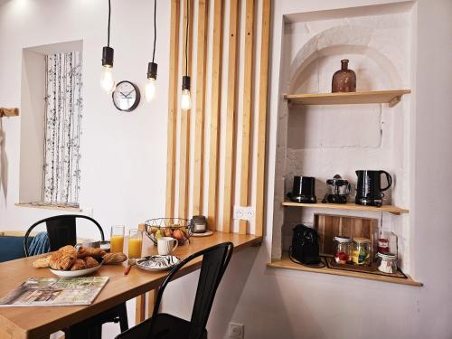 une cuisine avec une table avec de la nourriture dessus dans l'établissement Le jardin vert, paisible maison de ville, à Angoulême